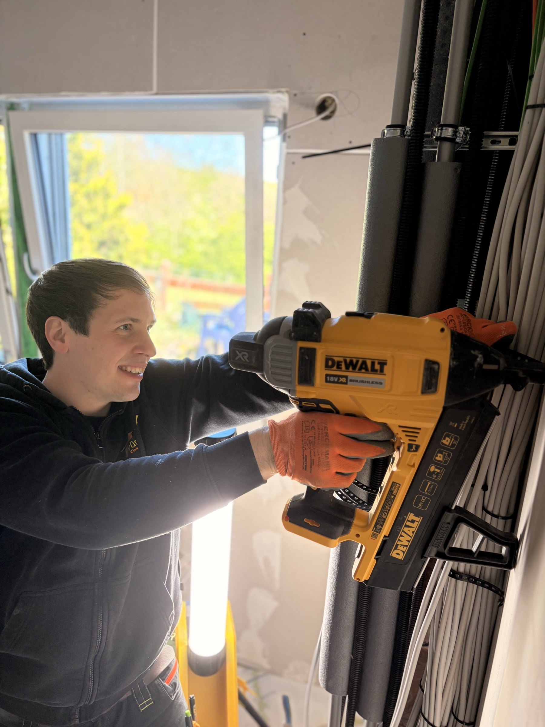 Elektriker bohrt an einer Schaltverteilung